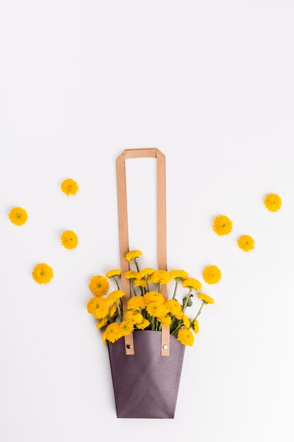 Tas met boeket in de buurt van bloemen