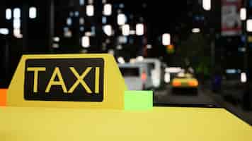 Gratis foto taxibord op gele auto nabij stadscentrum met wolkenkrabbers, moderne auto-personenauto die 's nachts op straat rond kantoorgebouwen rijdt. stedelijke metropool. detailopname. 3d render-animatie.