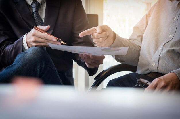 Teamwork proces. Jonge zakenmanagers die werken met een nieuw opstartproject. Labtop op kantoor houten tafel, toetsenbord typen, sms-bericht, grafiekplannen analyseren