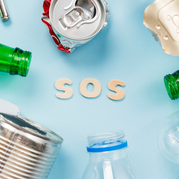 Tekst SOS met verschillende soorten afval