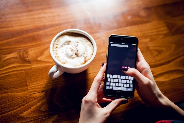 Telefoon houten beker hete koffie