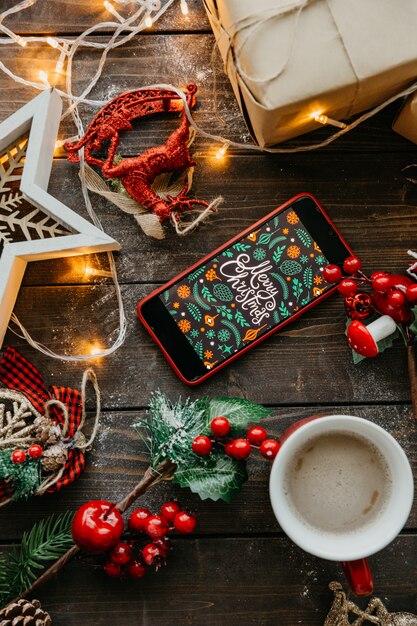 Telefoon met Kerst scherm en koffie met melk op de tafel