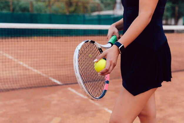 Tennis speler. Close-upfoto van atletenvrouw in sportkledingsholding racket en bal