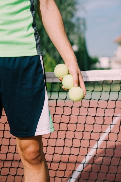 Tennis speler met drie ballen in de hand