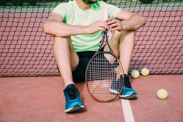 Gratis foto tennislaag leunend tegen netto