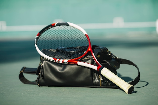 Gratis foto tennisracket met een tas op het tennisveld