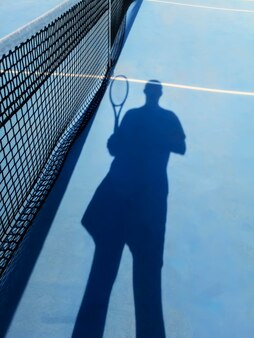 Tennisspeler en schaduw op een tennisbaan, tennisachtergrond