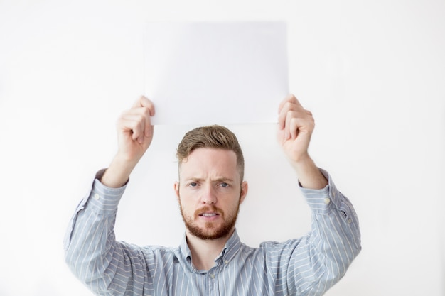 Tensed man holding sheet paper boven kop