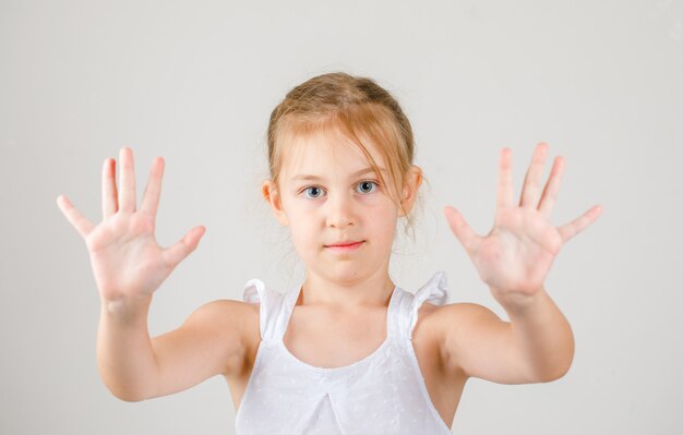 Terug naar school concept zijaanzicht. klein meisje toont haar handpalmen.