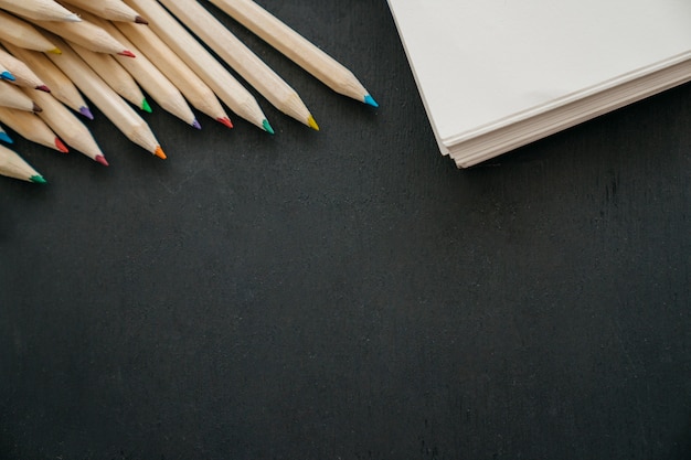 Gratis foto terug naar school decoratie met potloden, boek en ruimte