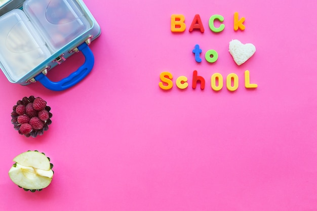 Gratis foto terug naar school het schrijven dichtbij fruit en lunchbox