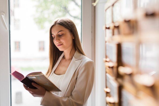 Terug naar schoolconcept met vrouw die in bibliotheek bestudeert