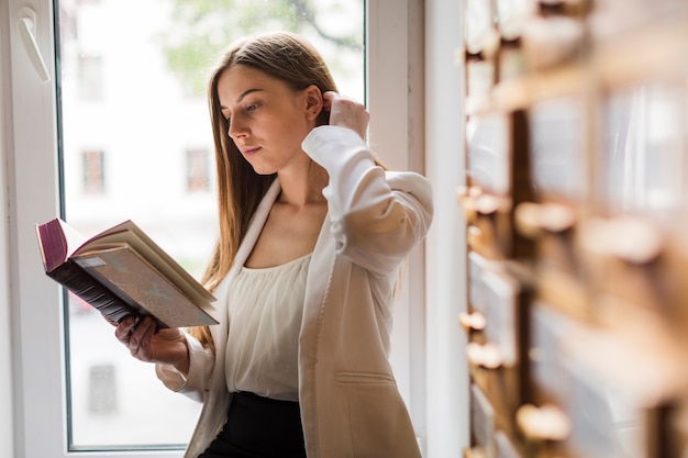 Terug naar schoolconcept met vrouw die in bibliotheek bestudeert