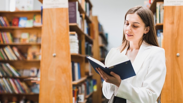 Gratis foto terug naar schoolconcept met vrouw die in bibliotheek bestudeert