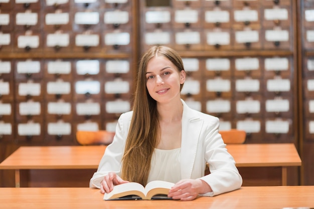 Terug naar schoolconcept met vrouw die in bibliotheek bestudeert