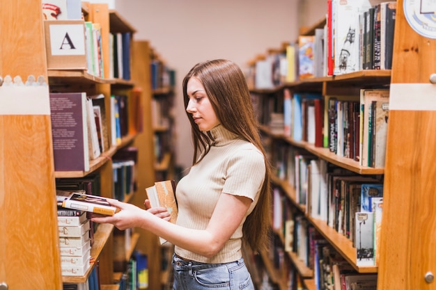 Terug naar schoolconcept met vrouw die in bibliotheek bestudeert