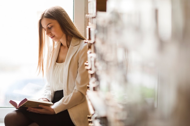 Terug naar schoolconcept met vrouw die in bibliotheek bestudeert