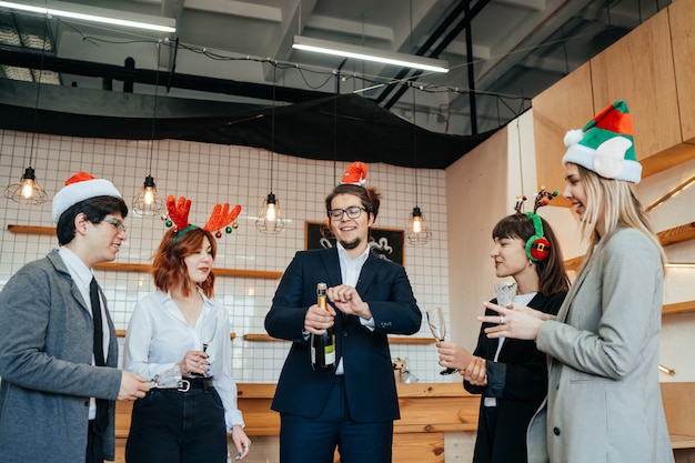 Tevreden collega's in kantoor vieren speciale gebeurtenis samen, glimlachend divers werkteam veel plezier lachen. Vriendschap concept