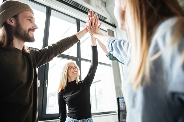 Tevreden collega's op kantoor geven elkaar high five