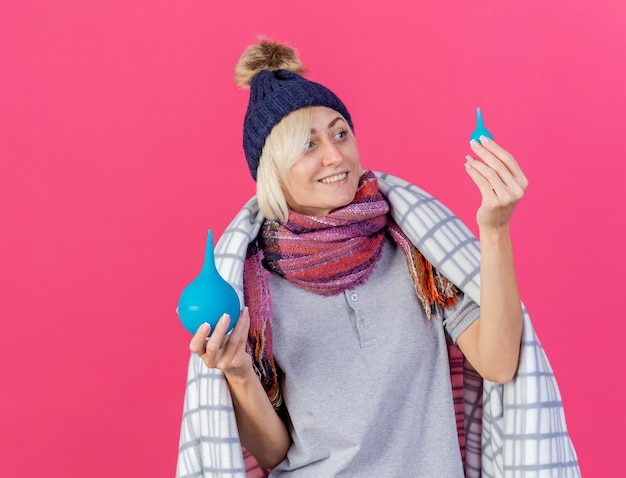 Tevreden jonge blonde zieke Slavische vrouw die de winterhoed draagt