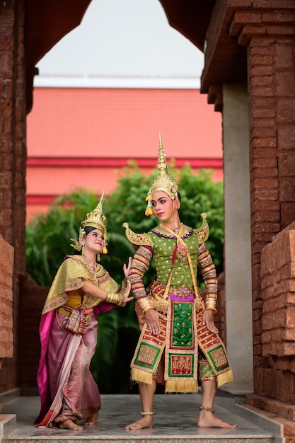 Gratis foto thailand dansend paar in gemaskerde khon-uitvoeringen met oude tempel