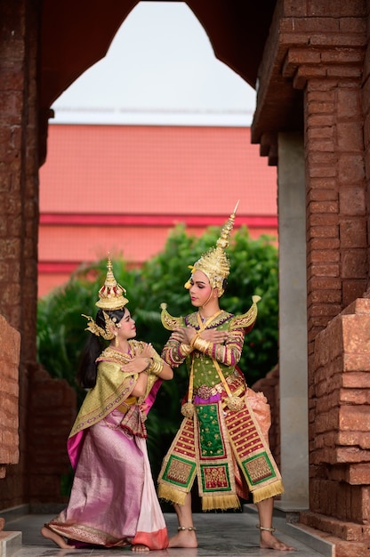 Thailand Dansend paar in gemaskerde Khon-uitvoeringen met oude tempel