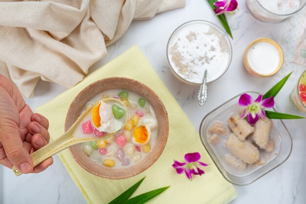 Thais dessert genaamd Bualoy-ballen in dippers met hete kokosmelk en pandanbladeren om de verrukking te vergroten.