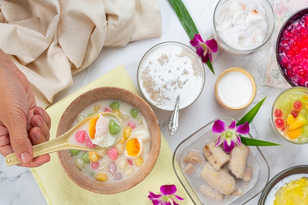 Thais dessert genaamd Bualoy-ballen in dippers met hete kokosmelk en pandanbladeren om de verrukking te vergroten.