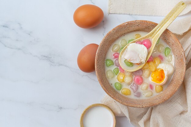 Thais dessert genaamd Bualoy-ballen in dippers met hete kokosmelk en pandanbladeren om de verrukking te vergroten.