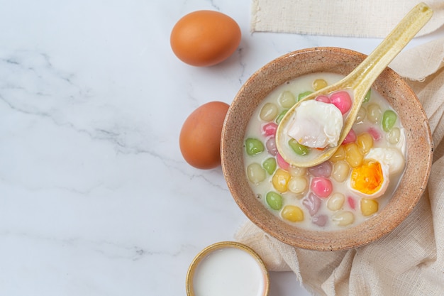 Thais dessert genaamd Bualoy-ballen in dippers met hete kokosmelk en pandanbladeren om de verrukking te vergroten.