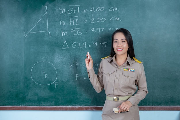 Thaise leraar in officiële outfit lesgeven voor bord