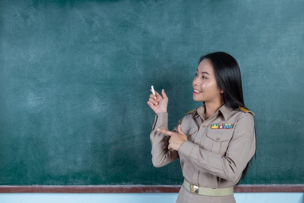 Thaise leraar in officiële outfit lesgeven voor bord