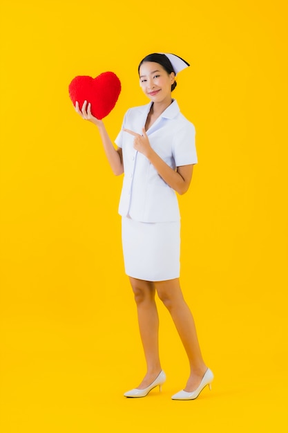 Thaise verpleegster van de portret de mooie jonge aziatische vrouw met de vorm van het harthoofdkussen