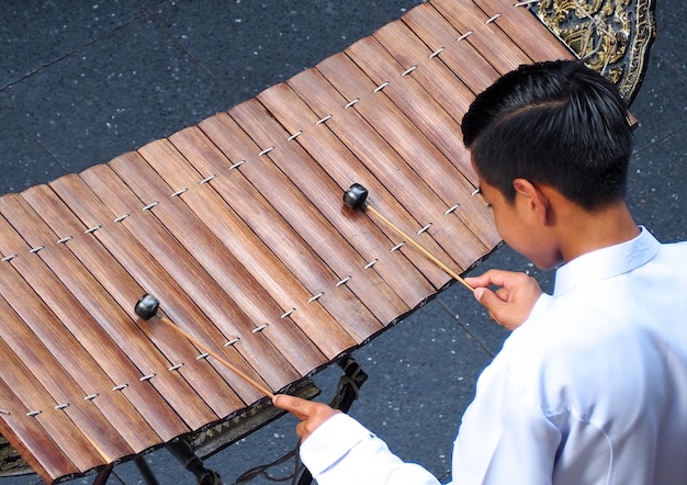 Thaise xylofoon gespeeld door thaise mensen die een wit vintage traditioneel pak en een bovenaanzichtcamera droegen.
