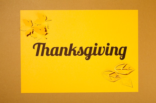 Gratis foto thanksgiving belettering met gele folders op papier