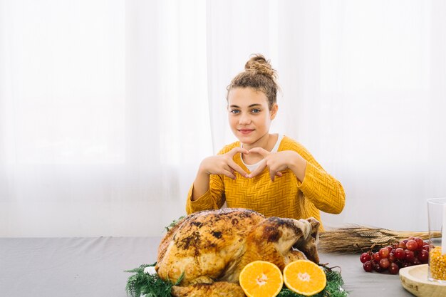 Thanksgiving gerechten met vrouw die hart vormt met handen