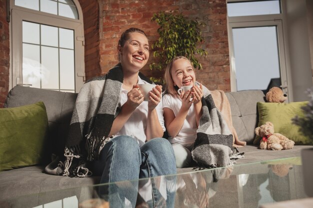 Thee drinken, praten. Moeder en dochter tijdens zelfisolatie thuis in quarantaine.