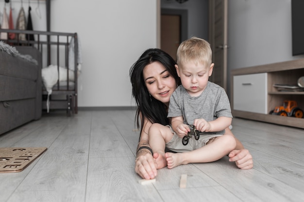 Thuis glimlachend het jonge vrouw spelen met haar weinig zoon