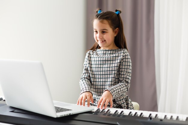 Thuisles over muziek voor het meisje op de piano. het idee van activiteiten voor het kind thuis tijdens quarantaine. muziek concept