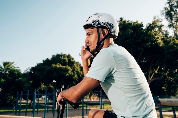 Tiener bmxruiter die op de telefoon spreekt