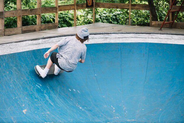 Tiener die dichtbij rand van kom met een skateboard rijdt