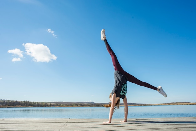 Tiener die handstand op pijler uitvoert