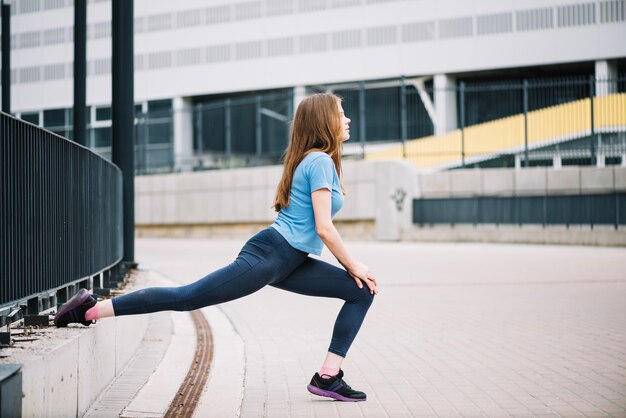 Tiener doet lunges in de buurt van hek