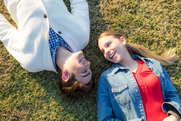 Tiener liggend op het gras met haar vriendje