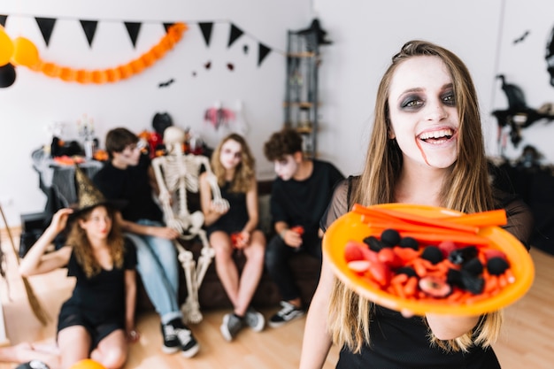 Tiener met onverbiddelijk Halloween en plaat met suikergoed