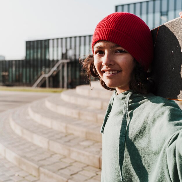 Tiener met skateboard in het park selfie te nemen