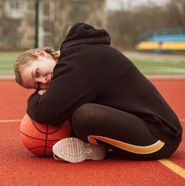 Gratis foto tiener poseren op het basketbalveld