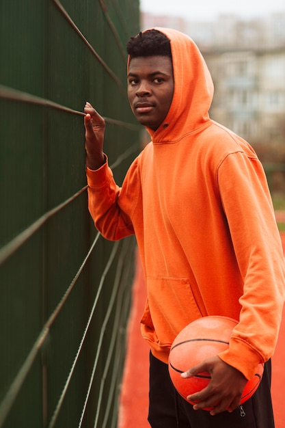 Gratis foto tiener poseren op het basketbalveld