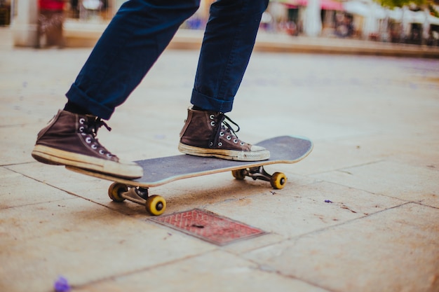 Tiener rijden skateboard op plaveisel vlag