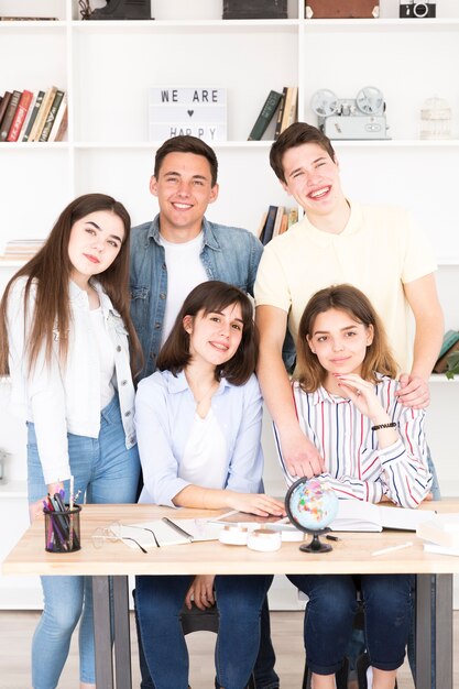 Tiener studenten verzamelden zich aan tafel in de klas